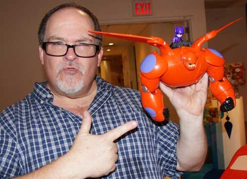 Jim Hill holds up the robot Baymax and his boy Hiro from Big Hero 6